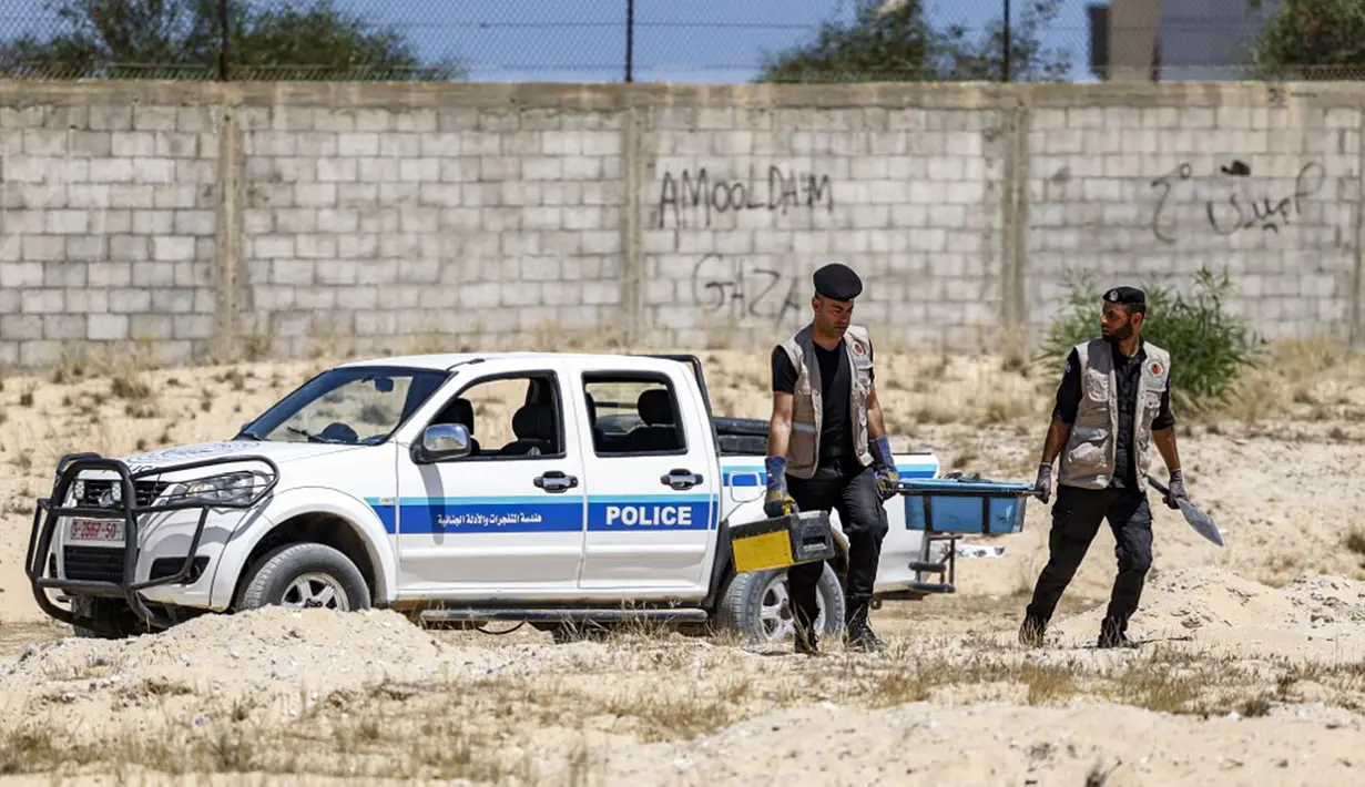 Pakar bahan peledak Hamas bersiap untuk mengambil proyektil yang tidak meledak setelah konflik Mei 2021 dengan Israel dari sebuah lapangan di Khan Yunis, Jalur Gaza, Sabtu (5/6/2021). Perang 11 hari antara Hamas dan Israel menewaskan 254 orang Palestina dan 12 orang Israel. (MAHMUD HAMS/AFP)