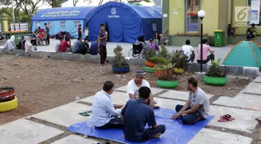 Para pencari suaka duduk-duduk di halaman gedung bekas Markas Kodim di kawasan Kalideres, Jakarta, Selasa (16/7/2019). Rata-rata para pencari suaka tersebut berasal dari Afghanistan, Pakistan, Somalia, Sudan, Iraq, dan Iran. (Liputan6.com/Helmi Fithriansyah)