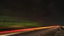Cahaya dari kendaraan yang melintas di State Route 26 terlacak dalam paparan kamera waktu sebagai aurora borealis, juga dikenal sebagai cahaya utara, terlihat pada langit malam dekat Washtucna, Washington, Amerika Serikat, 26 Februari 2023. Aktivitas tersebut telah membawa badai geomagnetik yang kuat pada Minggu malam dan dapat berlanjut dengan aktivitas sedang. (AP Photo/Ted S. Warren)