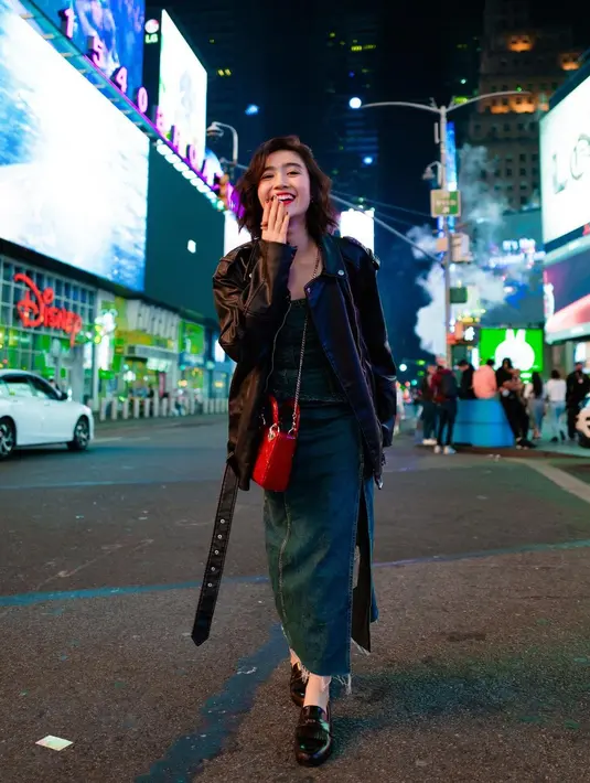 Gaya keren Febby Rastanty pakai dress denim dengan high slit sepaha, ditumpuknya mengenakan jaket kulit berwarna hitam, dan sling bag merah. [Foto: Instagram/febbyrastanty]