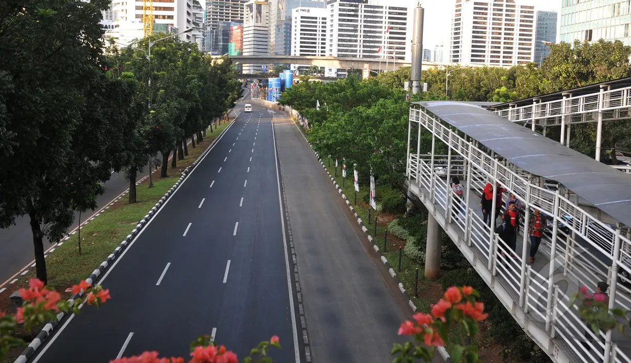 Jalan Sudirman - Thamrin terlihat kosong saat petugas kepolisian Polda Metro Jaya mengalihkan arus untuk tamu negara peserta Peringatan ke-60 Konferensi Asia Afrika yang melintas di kawasan Semanggi, Jakarta, Senin (20/4/2015).(Liputan6.com/Johan Tallo)