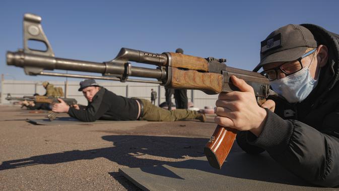 Seorang pria memegang senjata selama pelatihan perang dasar untuk warga sipil oleh Unit Pasukan Khusus Azov, dari Garda Nasional Ukraina, di Mariupol, wilayah Donetsk, Minggu (13/2/2022). Mereka disiapkan untuk bisa bertahan di tengah kekhawatiran akan invasi Rusia. (AP Photo/Vadim Ghirda)