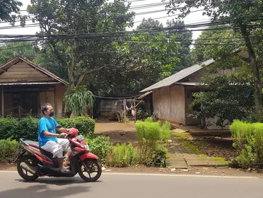 Warga melintas di lahan di RT 05/RW 05 Kelurahan Pondok Ranggon yang dikabarkan jadi lokasi pembangunan DP Rp 0, Jakarta Timur, Rabu (10/3/2021). KPK sedangmenyelidiki Program Rumah DP 0 Rupiah di Munjul, Kelurahan Pondok Ranggon, Kecamatan Cipayung, Jakarta Timur. (Liputan6.com/Herman Zakharia)