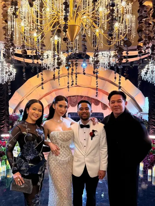 Yura tampil anggun dalam gaun hitam berpotongan one-shoulder yang memberi kesan modern dan refined. Ia melengkapi tampilannya dengan tas hitam kecil yang senada.
Donne tampil rapi dalam setelan hitam klasik, berdiri berdampingan dengan Yura di tengah dekorasi megah berhiaskan chandelier dan rangkaian bunga. Keduanya memancarkan aura couple elegan yang tenang dan dewasa. [@yurayunita].