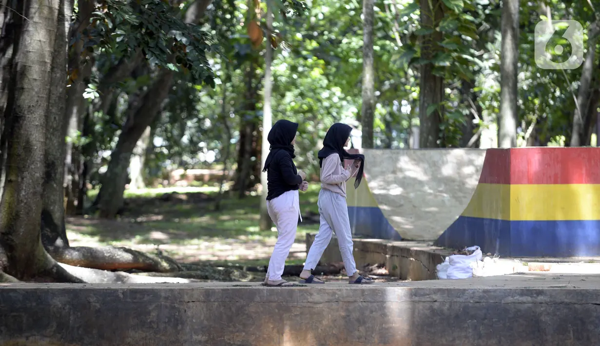 Warga berjalan di Taman Kota 1, Tangerang Selatan, Banten, Selasa (1/12/2020). Kawasan terbuka hijau seluas 7,2 hektare tersebut sebagai tempat rekreasi alam murah meriah. (merdeka.com/Dwi Narwoko)