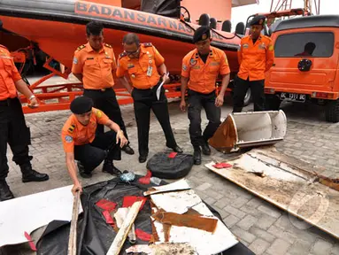 Petugas Basarnas Palu memperlihatkan sejumlah serpihan yang diduga milik Pesawat AirAsia di halaman kantor Basarnas, Sulawesi Tengah, Rabu (4/2/2015). (Liputan6.com/Dio Pratama)