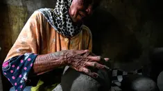 Seorang pembuat tembikar membuat pot tanah liat menggunakan tangan dalam bengkel rumah di Banda Aceh, Aceh, Rabu (4/8/2021). (CHAIDEER MAHYUDDIN/AFP)