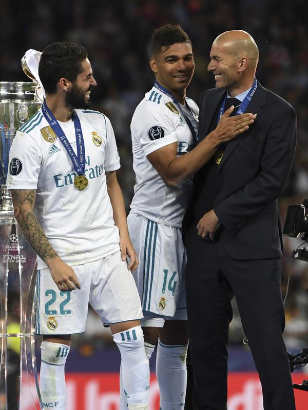 Isco (kiri) dan Casemiro tertawa bersama Zidane usai meraih trofi Liga Champions 2018 di Olympic Stadium, Kiev, Ukraina, (26/5/2018). Zinedine mundur sebagai pelatih Madrid 31 Mei 2018. (AFP/Paul Ellis)