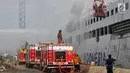 Pemadam kebakaran berusaha memadamkan api yang membakar kapal Panorama Nusantara di Pelabuhan Tanjung Mas, Semarang, Senin (18/2). Enam mobil dan dua kapal pemadam kebakaran dikerahkan untuk memadamkan api. (Liputan6.com/Gholib)