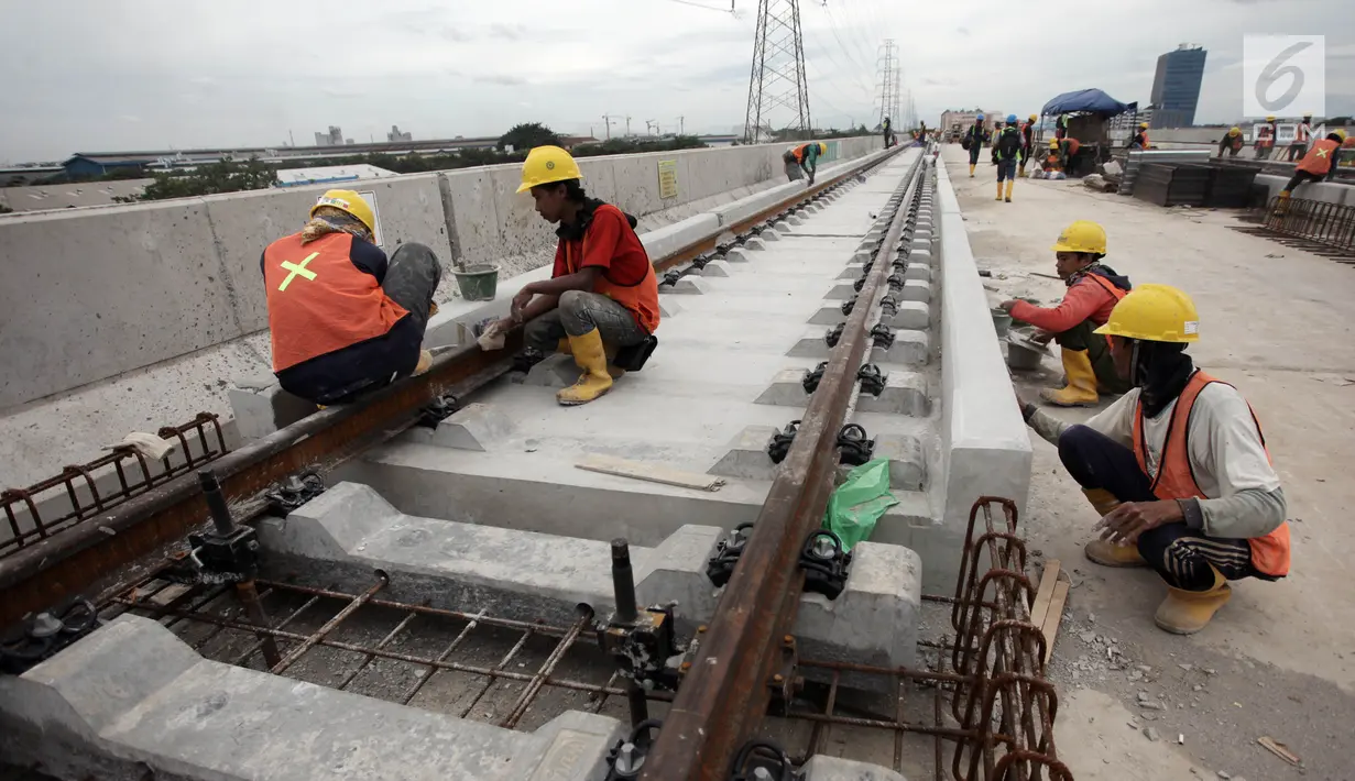 Pekerja mengerjakan bantalan rel di Depo LRT, Kelapa Gading, Jakarta Utara, Kamis (25/1). Nantinya, LRT terdiri dari empat gerbong dalam satu rangkaian. (Liputan6.com/Arya Manggala)
