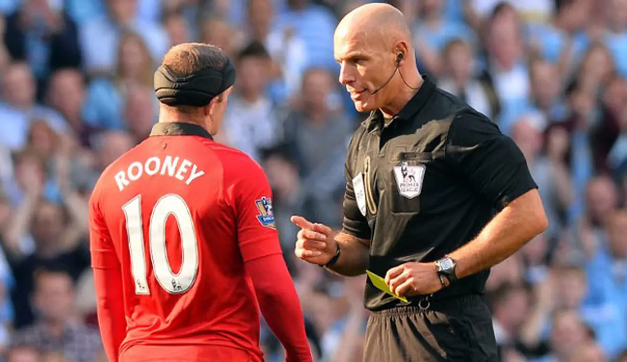 Wayne Rooney mendapatkan kartu kuning oleh wasit Howard Webb pada pertandingan sepak bola Liga Premier Inggris antara Manchester City vs Manchester United di Stadion Etihad, Manchester (22/09/13). (AFP/Paul Ellis)