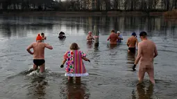 Anggota klub renang es "Berliner Seehunde" berenang di danau Orankesee, sebagai perayaan tahun baru di Berlin, Jerman (1/1). Terlihat kebanyakan dari mereka adalah orang tua berusia lanjut. (REUTERS/Fabrizio Bensch)