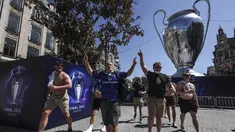Suporter Chelsea berjalan melewati replika raksasa trofi Liga Champions di pusat kota Porto, Portugal (28/5/2021). Klub Inggris Manchester City dan Chelsea akan memainkan final Liga Champions di stadion Dragao di Porto pada Sabtu malam atau Minggu (30/5/2021) dini hari. (AP Photo/Luis Vieira)