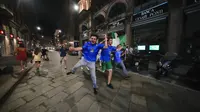 Suporter merayakan kemenangan Italia atas Inggris pada pertandingan final Euro 2020 di Milan, Italia, Senin (12/7/2021). Italia menjuarai Euro 2020 usai mengalahkan Inggris lewat drama adu penalti pada pertandingan final. (AP Photo/Luca Bruno)