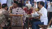Presiden Joko Widodo (Jokowi) berbincang sambil menjajal makanan saat meninjau Rest Area 538 seusai meresmikan ruas  Tol Sragen-Ngawi, Jawa Tengah, Rabu (28/11). Jokowi duduk semeja dengan kepala serta pimpinan daerah setempat. (Liputan6.com/Angga Yuniar)