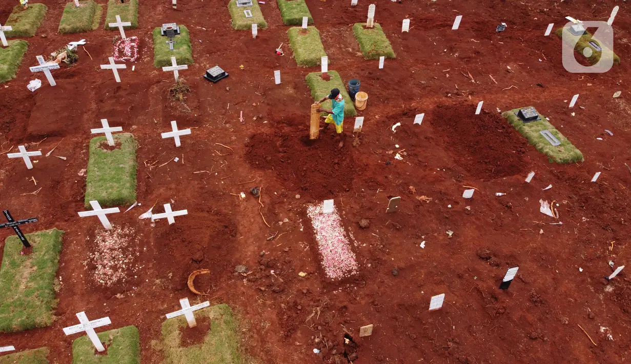 Foto udara menggambarkan petugas sedang melakukan perawatan lokasi pemakaman jenazah yang diduga terinfeksi Covid-19 di TPU Pondok Ranggon, Jakarta, Kamis {30/4/2020). Sejumlah makam terlihat mulai dipasangi rumput dan batu nisan. (Liputan6.com/Helmi Fithriansyah)