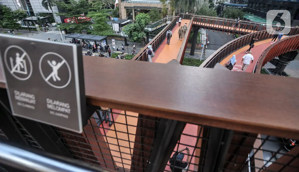 Warga berfoto saat ngabuburit di JPO Pinisi Pinisi Karet-Sudirman, Jakarta Pusat, Senin (4/4/2022). JPO Pinisi kini menjadi destinasi baru warga Jakarta untuk menunggu waktu berbuka puasa atau ngabuburit sambil menikmati suasana perkotaan. (merdeka.com/Iqbal S. Nugroho)