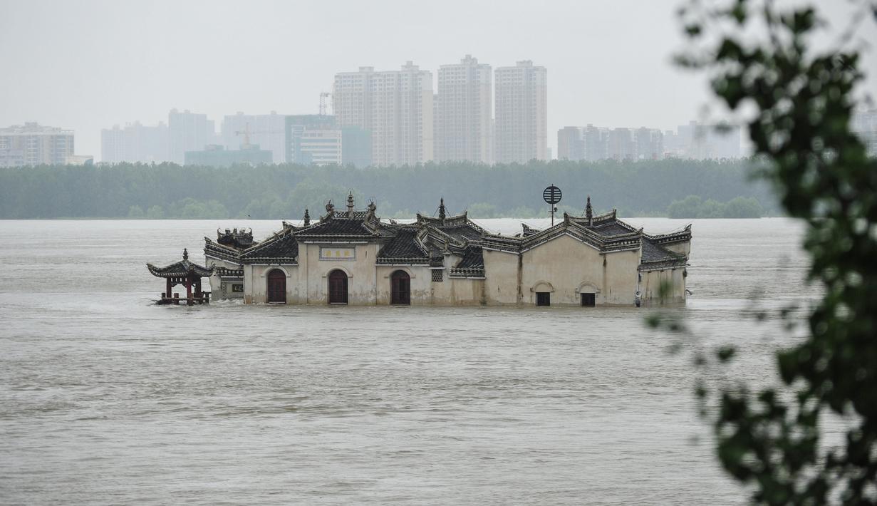 Foto pada 19 Juli 2020 menunjukkan kuil Guanyinge berumur 700 tahun yang dibangun di atas batu, terendam banjir akibat meluapnya sungai Yangtze di Wuhan, provinsi Hubei. Hujan lebat sejak bulan Juni telah menyebabkan sedikitnya 141 orang tewas dan memaksa hampir 15 juta orang dievakuasi. (STR/AFP)