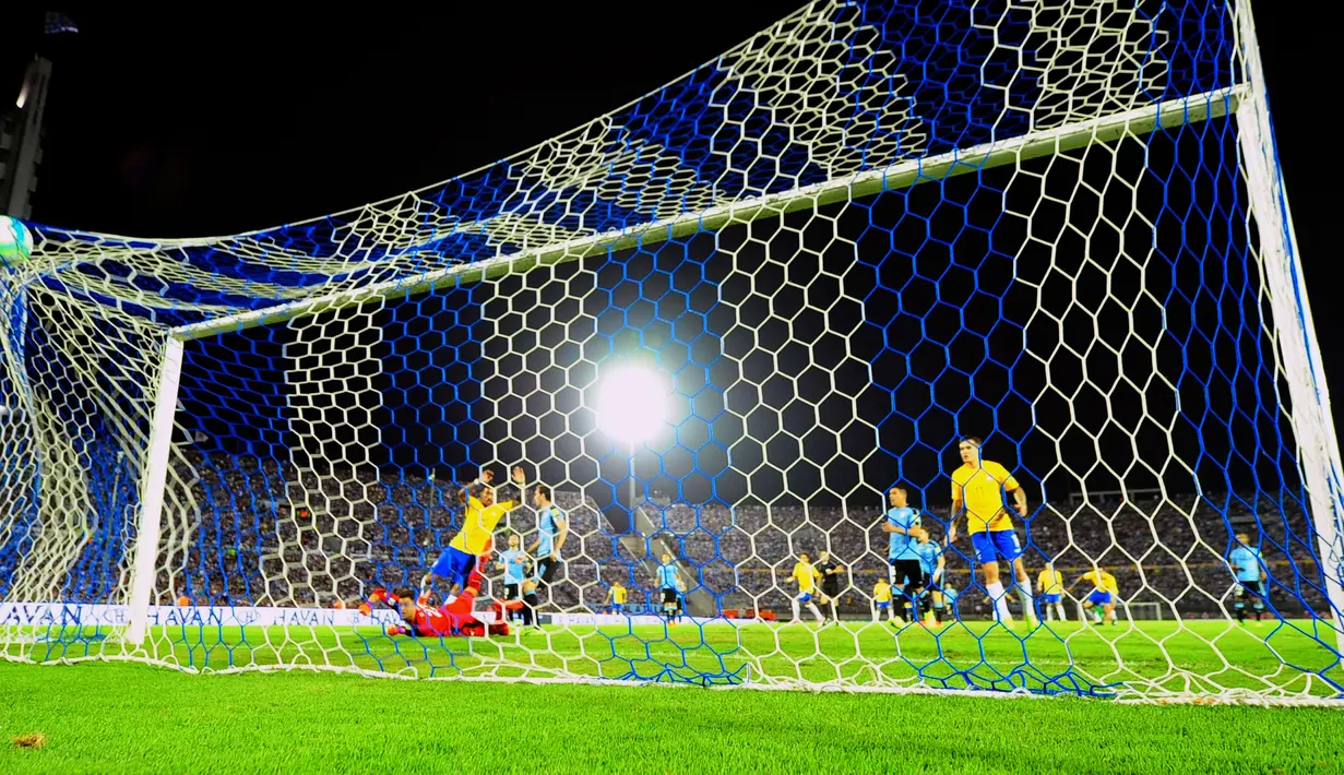 Gelandang Brasil, Paulinho (kiri) saat membobol gawang Uruguay pada laga kualifikasi Piala Dunia 2018 zona Amerika Selatan di Stadion Centenario, Kamis (23/3). Timnas Brasil memetik kemenangan telak 4-1 atas tuan rumah Uruguay. (Dante FERNANDEZ / AFP)