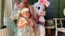 Hilary Duff berpose bersama kedua anaknya. Dengan outfit seragam, yaitu dress bermotif floral yang cantik, yang menarik adalah boneka kelinci besar berwarna putih di belakang Hilary. Foto: Instagram.