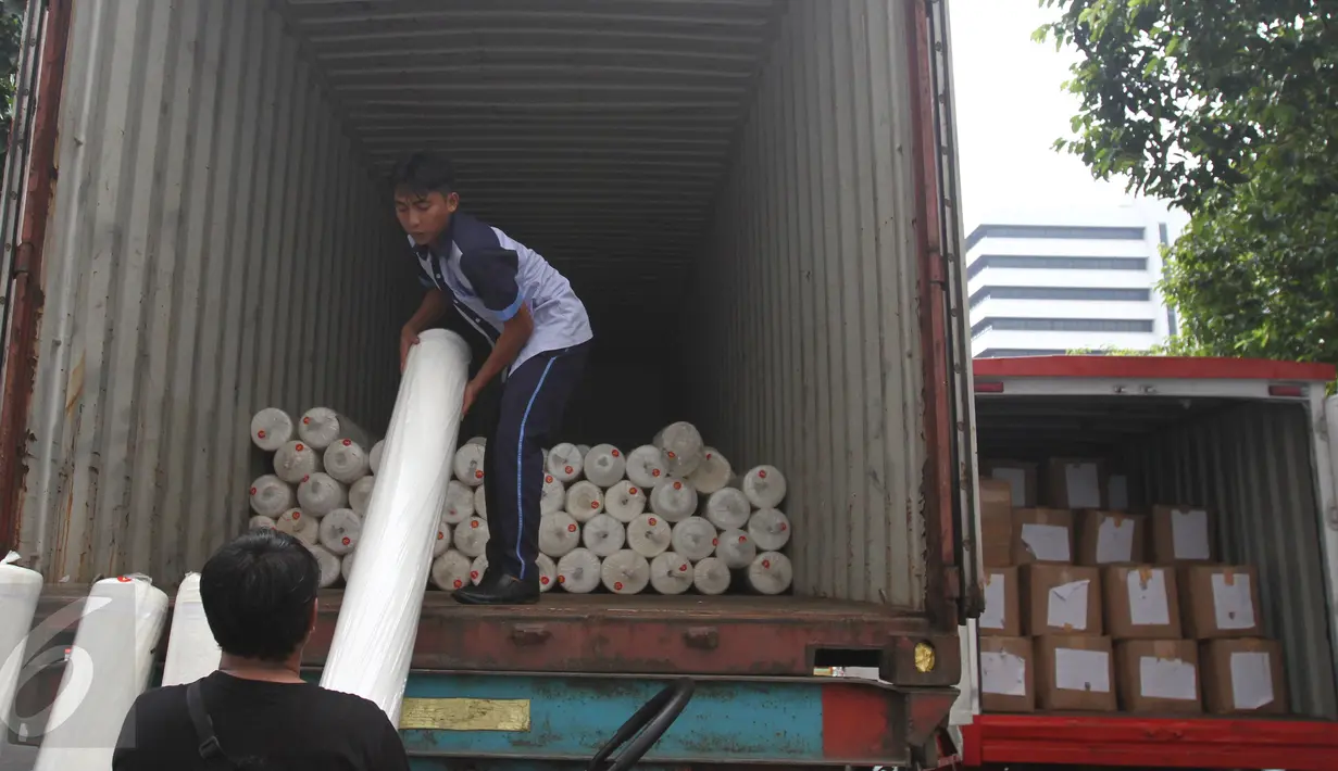 Petugas menurunkan gulungan kain teksil selundupan dari dalam truk, di Jakarta, Rabu (3/5). Berdasarkan hasil audit investigasi, kerugian negara akibat pelanggaran ini diperkirakan kurang lebih sebesar Rp118 Miliar. (Liputan6.com/Angga Yuniar)