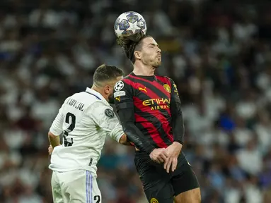 Gelandang Manchester City, Jack Grealish berebut bola udara dengan bek Real Madrid, Dani Carvajal selama pertandingan leg pertama semifinal Liga Champions di stadion Santiago Bernabeu di Madrid, Spanyol, Selasa, 9 Mei 2023. (AP Photo/Jose Breton)