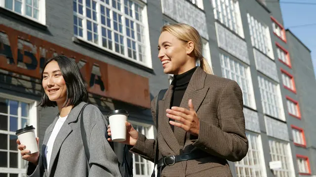 Dua orang memegang gelas kopi