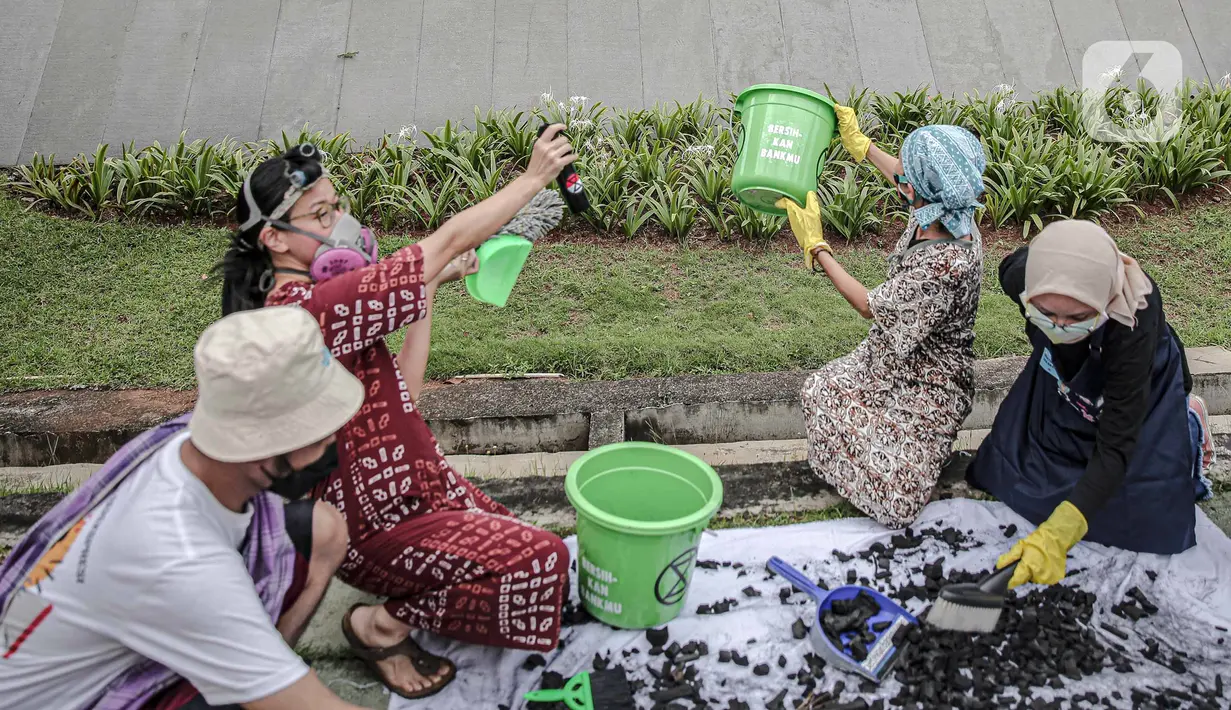 Aktivis melakukan aksi Jeda untuk Iklim di depan Plaza Mandiri, Jakarta, Selasa (25/1/2022). Aktivis menuntut komitmen bank nasional di Indonesia yang masih membiayai industri batu bara dan pertambangan yang merupakan penyumbang emisi terbesar kedua di Indonesia. (Liputan6.com/Faizal Fanani)