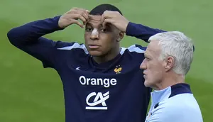 Pemain Prancis, Kylian Mbappe (kiri) di samping pelatih Didier Deschamps saat berlatih jelang laga Grup D melawan Belanda di Home Deluxe Arena Stadium, Paderborn, Jerman, Rabu (19/06/2024) waktu setempat. Mbappe terlihat menggunakan perban hidung setelah mengalami cedera patah tulang hidung pada laga Grup D Prancis melawan Austria Selasa (18/06/2024) WIB lalu. (AP Photo/Hassan Ammar)
