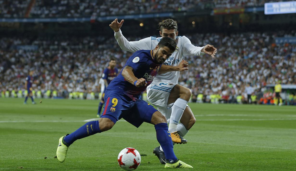 Pemain Barcelona, Luis Suarez mencoba melewati adangan pemain Real Madrid, Mateo Kovacic pada leg kedua Piala Super Spanyol di Santiago Bernabeu stadium (16/8/2017). Real menang 2-0. (AP/Francisco Seco)