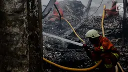 Petugas pemadam kebakaran melakukan pendinginan usai kebakaran yang melanda gudang kosmetik di Jalan Bandengan 1 No 56, RT 04/12, Kelurahan Pekojan, Kecamatan Tambora, Jakarta Barat, Senin (4/12). (Liputan6.com/Faizal Fanani)
