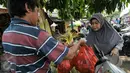 Warga membeli kulit ketupat untuk bahan membuat ketupat yang menjadi makanan khas di Hari Raya Idul Fitri, Jakarta, Senin (4/7). Jelang Hari Raya Idul Fitri, pedagang kulit ketupat mulai kebajiran pembeli. (Liputan6.com/Yoppy Renato)