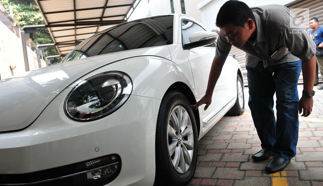 Calon peserta lelang mengecek kondisi mobil hasil sitaan kasus korupsi di Gedung KPK, Jakarta, Selasa (19/9). KPK melelang sebanyak 19 unit mobil dari berbagai model dan merek dengan harga termurah Rp28,8 jutaan. (Liputan6.com/Helmi Afandi)