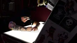 Seniman tato Tiffany Garcia membuat pola tato gelombang suara atau Soundwave Tattoo di Black Raven Tattoo California, 12 April 2018. Pola gelombang audio atau gambar dicetak dan ditempelkan ke bagian tubuh layaknya tato. (AFP/FREDERIC J. BROWN)