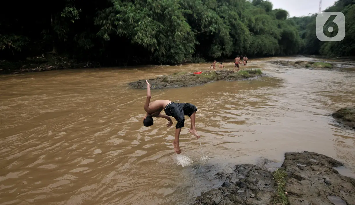 Anak-anak berenang di Kali Ciliwung, Depok, Jawa Barat, Minggu (27/6/2021). Keterbatasan lahan bermain di tengah masa pandemi COVID-19 membuat anak-anak memilih untuk berenang di Kali Ciliwung sebagai wahana alternatif saat libur sekolah. (merdeka.com/Iqbal S. Nugroho)