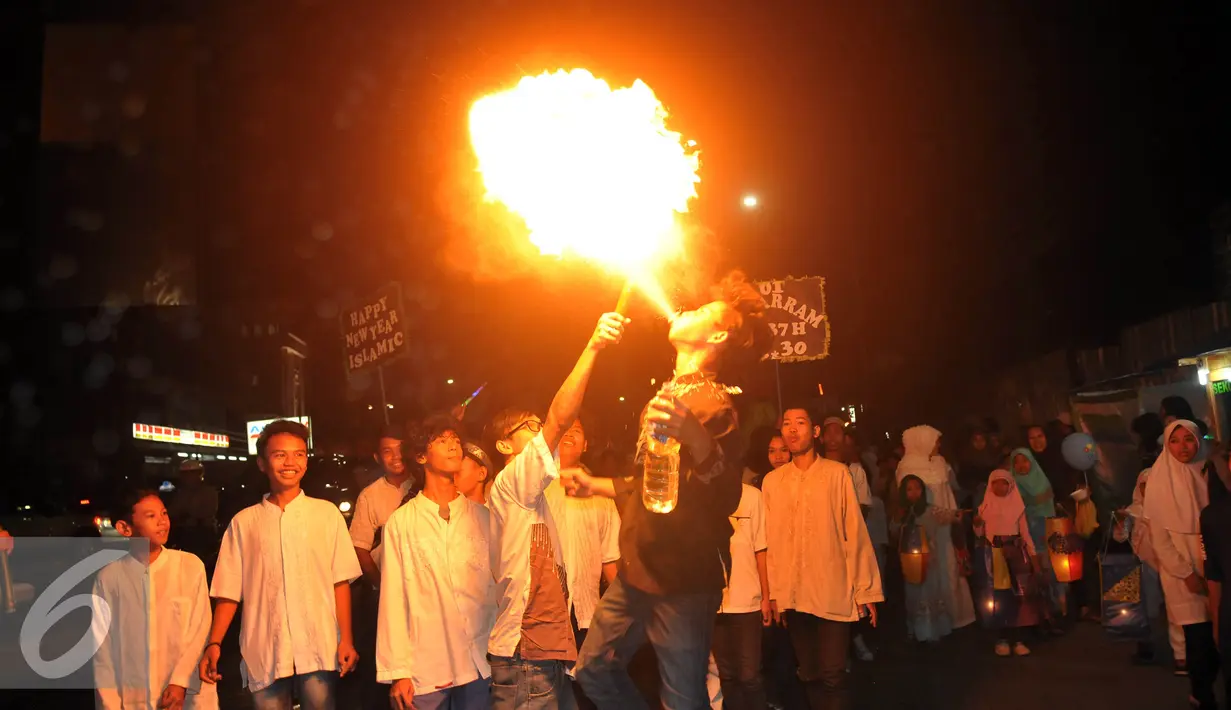 Seorang warga melakukan semburan api saat pawai di kawasan Buncit Raya, Jakarta, Selasa (13/10/2015). Pawai ini dalam rangka menyambut tahun baru 1 Muharram 1437 Hijriah pada Rabu 14 oktober 2015. (Liputan6.com/Johan Tallo)