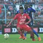 Duel bek Persija Jakarta, Tony Sucipto, dan gelandang serang Arema FC, Makan Konate, dalam laga pekan ke-28 Shopee Liga 1 2019 di Stadion Kanjuruhan, Malang, Sabtu (23/11/2019). Arema dan Persija bermain imbang 1-1. (Bola.com/Iwan Setiawan)