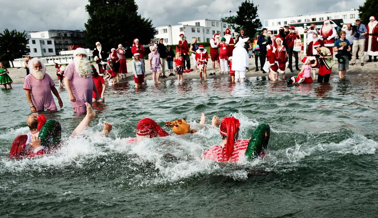 Keseruan sinterklas dari seluruh dunia bermain air pada hari kedua Konvensi Musim Panas Sinterklas ke-59 di Kopenhagen, Denmark, 19 Juli 2016. Mereka memulai pagi hari dengan berenang di pantai Bellevue. (Mathias Loevgreen Bojesen/Scanpix Denmark/AFP)