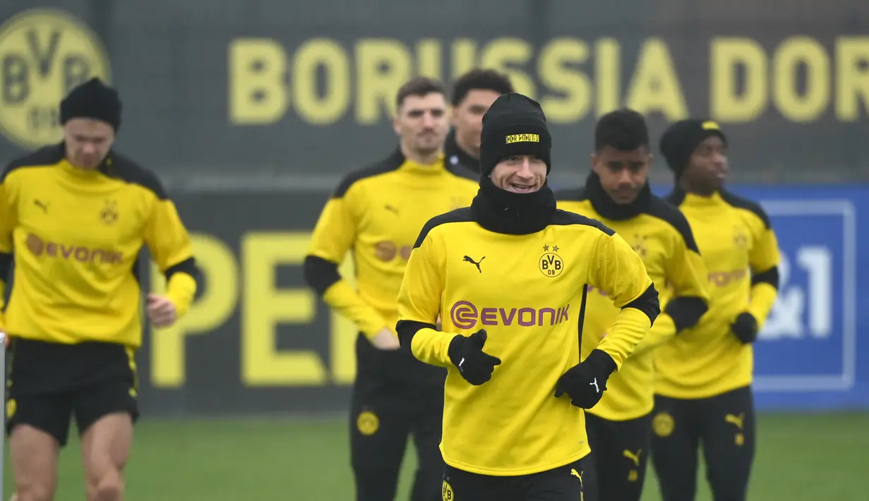 Para pemain Borrusia Dortmund melakukan pemanasan selama sesi latihan di tempat latihan tim di Dortmund, Jerman barat (9/3/2021). Dortmund akan bertanding melawan Sevilla pada leg kedua babak 16 besar Liga Champions di Signal Iduna Park. (AFP/Ina Fassbender)