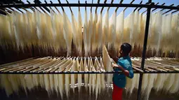 Pekerja menjemur bihun yang digunakan dalam hidangan manis tradisional yang populer dikonsumsi selama bulan suci Ramadhan di sebuah pabrik di Allahabad, India (13/4/2021). (AFP Photo/Sanjay Kanojia)