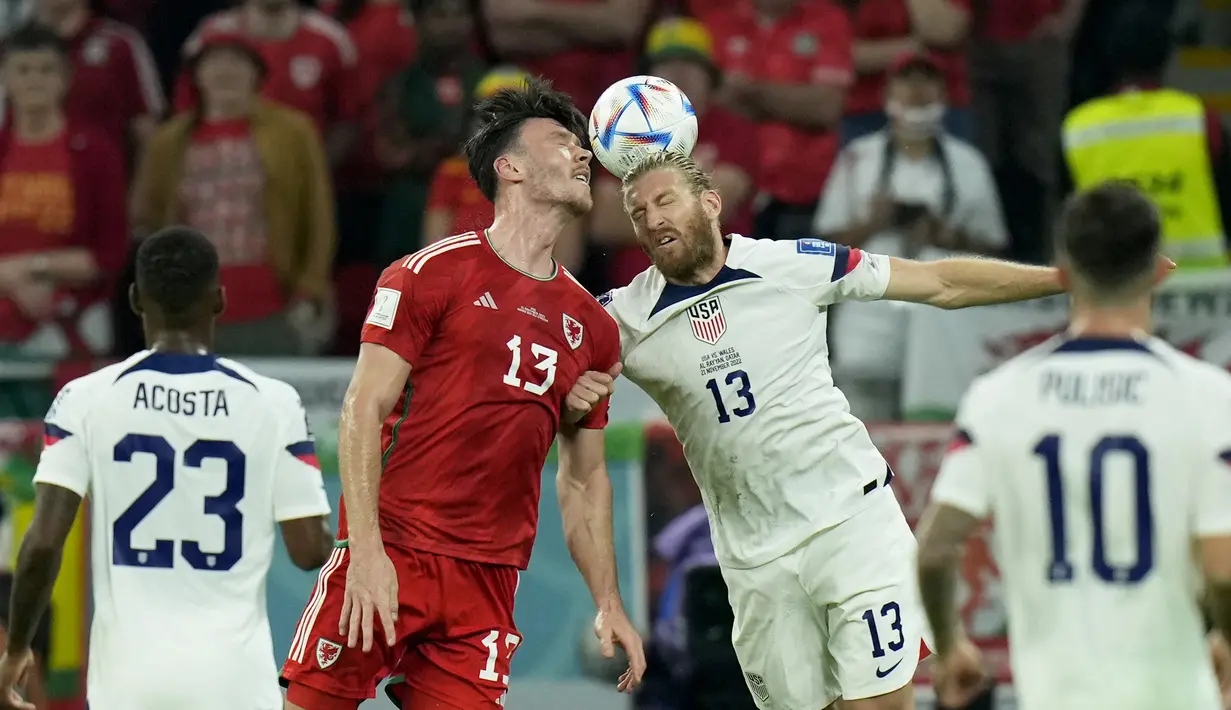 Pemain Wales,  Kieffer Moore berebut bola udara dengan pemain Amerika Serikat, Tim Ream selama pertandingan Piala Dunia 2022 Qatar di Stadion Ahmad Bin Ali di Doha, Qatar, Selasa (22/11/2022). Amerika Serikat bermain imbang dengan Wales dengan skor 1-1. (AP Photo/Francisco Seco)