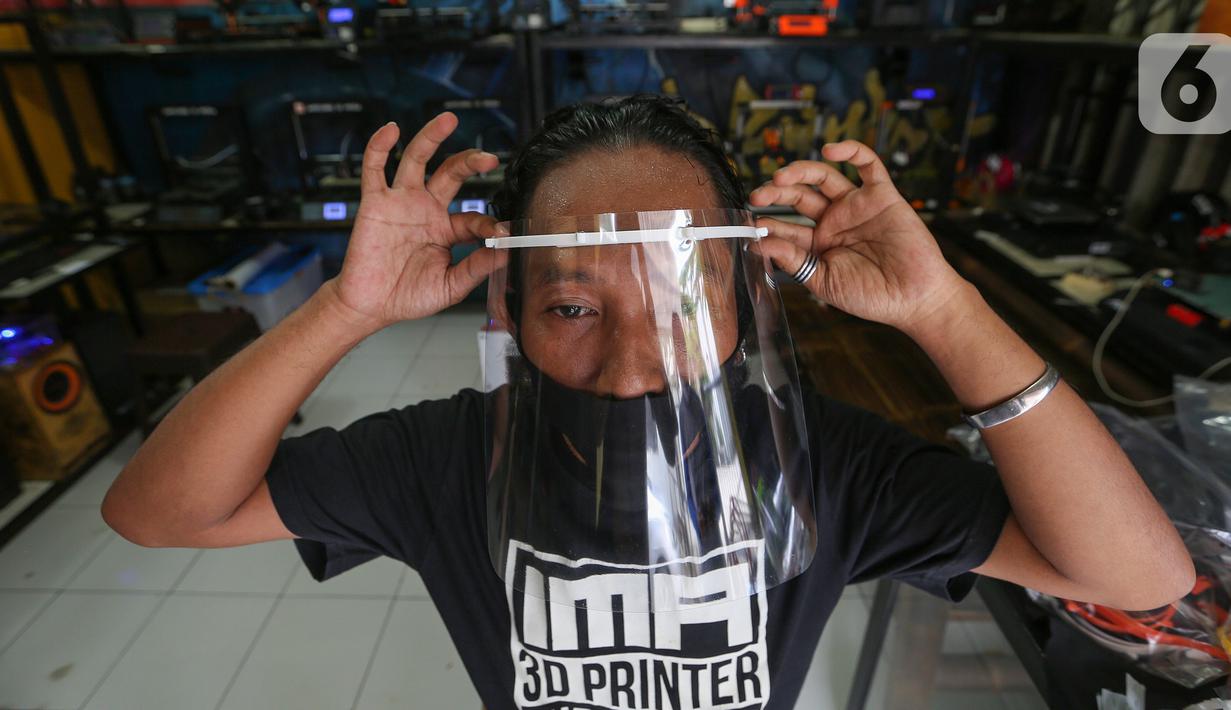 Sukarelawan 3D mencoba face shield atau pelindung wajah di IMA 3D, Cipondoh, Kota Tangerang, Kamis (23/4/2020). Sukarelawan 3D ini mampu memproduksi face shield atau pelindung wajah sebanyak 100 buah per hari untuk donasi tenaga medis selama pandemi Covid-19. (Liputan6.com/Fery Pradolo)