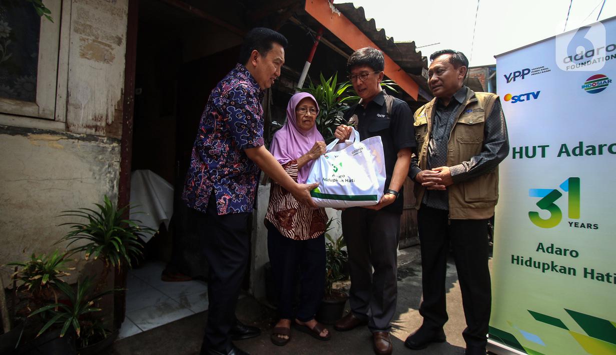 Dirut PT Surya Citra Media Tbk Sutanto Hartono, Ketua Umum Yayasan Pundi Amal Peduli Kasih Imam Sudjarwo dan Presdir PT Adaro Energy Indonesia Tbk Garibaldi Thohir saat membagikan sembako langsung kepada warga di Kampung Bali RW 05, Kebon Jeruk, Jakarta, Rabu (4/10/2023). PT Adaro Energi Tbk bersama Yayasan Pundi Amal Peduli Kasih (YPP) SCTV dan Indosiar menggelar kegiatan penyerahan sembako dalam rangka Hari Ulang Tahun (HUT) Adaro ke-31 dengan tema “Adaro Hidupkan Hati”. (Liputan6.com/Angga Yuniar)