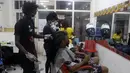 Penata rambut, memakai masker untuk melindungi dari virus corona, mengecat rambut pelanggan di dalam salon di Lagos, Nigeria, Rabu (26/5/2021). (AP Photo/Sunday Alamba)