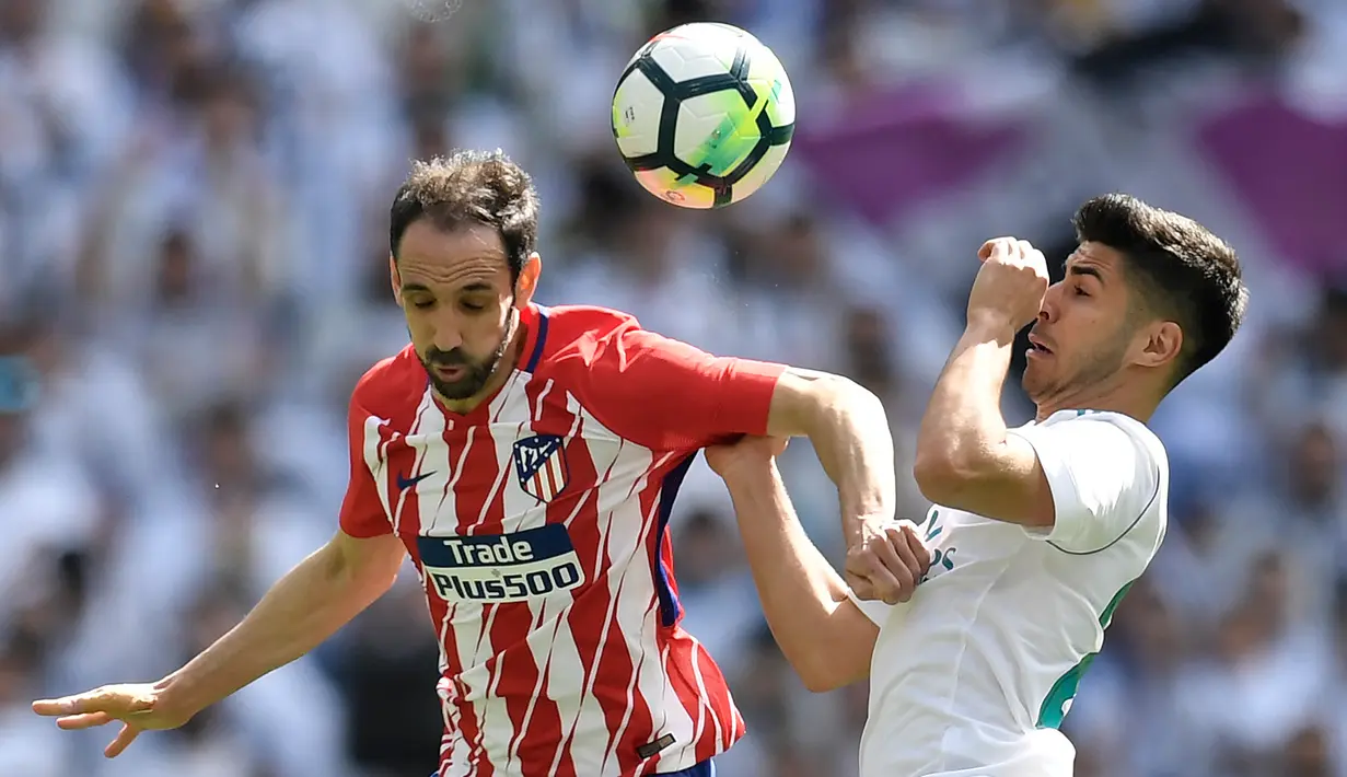 Gelandang Real Madrid Marco Asensio berebut bola dengan bek Atletico Madrid Juanfran saat pertandingan La Liga Spanyol di stadion Santiago Bernabeu di Madrid (8/4). (AFP/Gabriel Bouys)