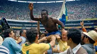 Pemain Brasil Pele diangkat rekan satu timnya setelah Brasil memenangkan final Piala Dunia melawan Italia di Estadio Azteca, Mexico City, 21 Juni 1970. Legenda sepak bola dunia itu mengembuskan nafas terakhir pada usia 82 tahun. (AP Photo, File)