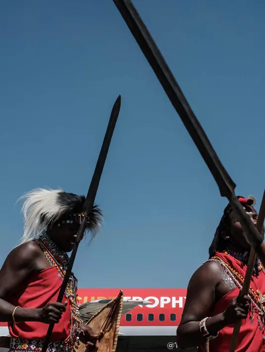Penari suku Maasai Kenya tampil pada saat kedatangan pesawat khusus yang membawa trofi Piala Dunia FIFA selama Tur Dunia di bandara Internasional Jomo Kenyatta di Nairobi (26/2). (AFP Photo/Yasuyoshi Chiba)
