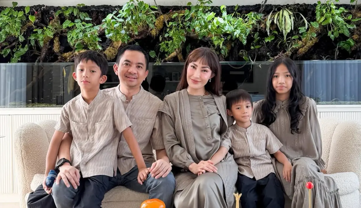 Ayu Dewi tampil kompak bersama keluarga mengenakan busana bernuansa abu-abu. Ayu Dewi mengenakan atasan tunik dipadukan rok panjangnya. [@ayudewi777]