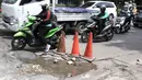 Pengendara menghindari jalan berlubang di kawasan Tanjung Barat, Jakarta, Rabu (30/1). Kondisi jalan rusak tersebut telah beberapa kali menyebabkan kecelakaan sehingga butuh penanganan. (Liputan6.com/Immanuel Antonius)