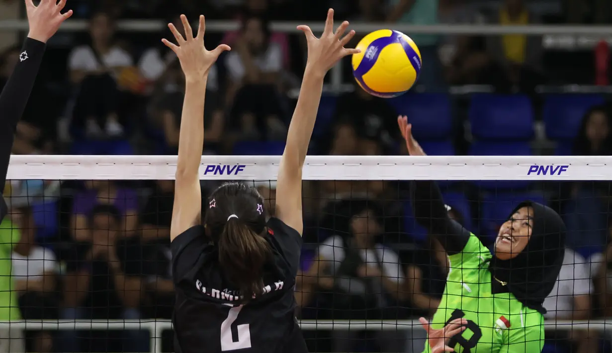 <p>Pemain Timnas voli putri Indonesia, Putri Agustin (kanan) melepaskan spike yang berusaha diblok pemain Singapura, Nadja Kim Schmidt pada laga Grup B AVC Challenge Cup 2024 di Rizal Memorial Coliseum, Manila, Filipina, Jumat (24/5/2024). Indonesia menang 3-0 (25-14, 25-13, 25-14). (Asian Volleyball Confederation)</p>